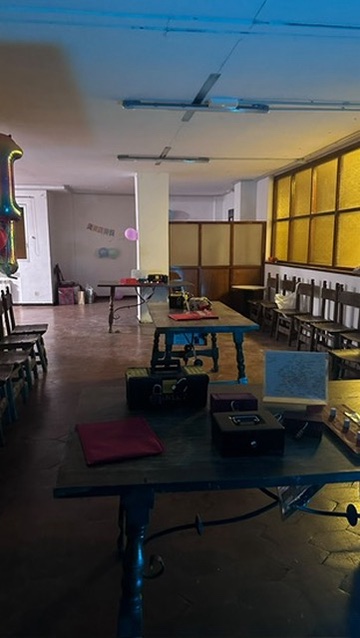 Salón preparado con mesas de equipo para un cumpleaños con escape room