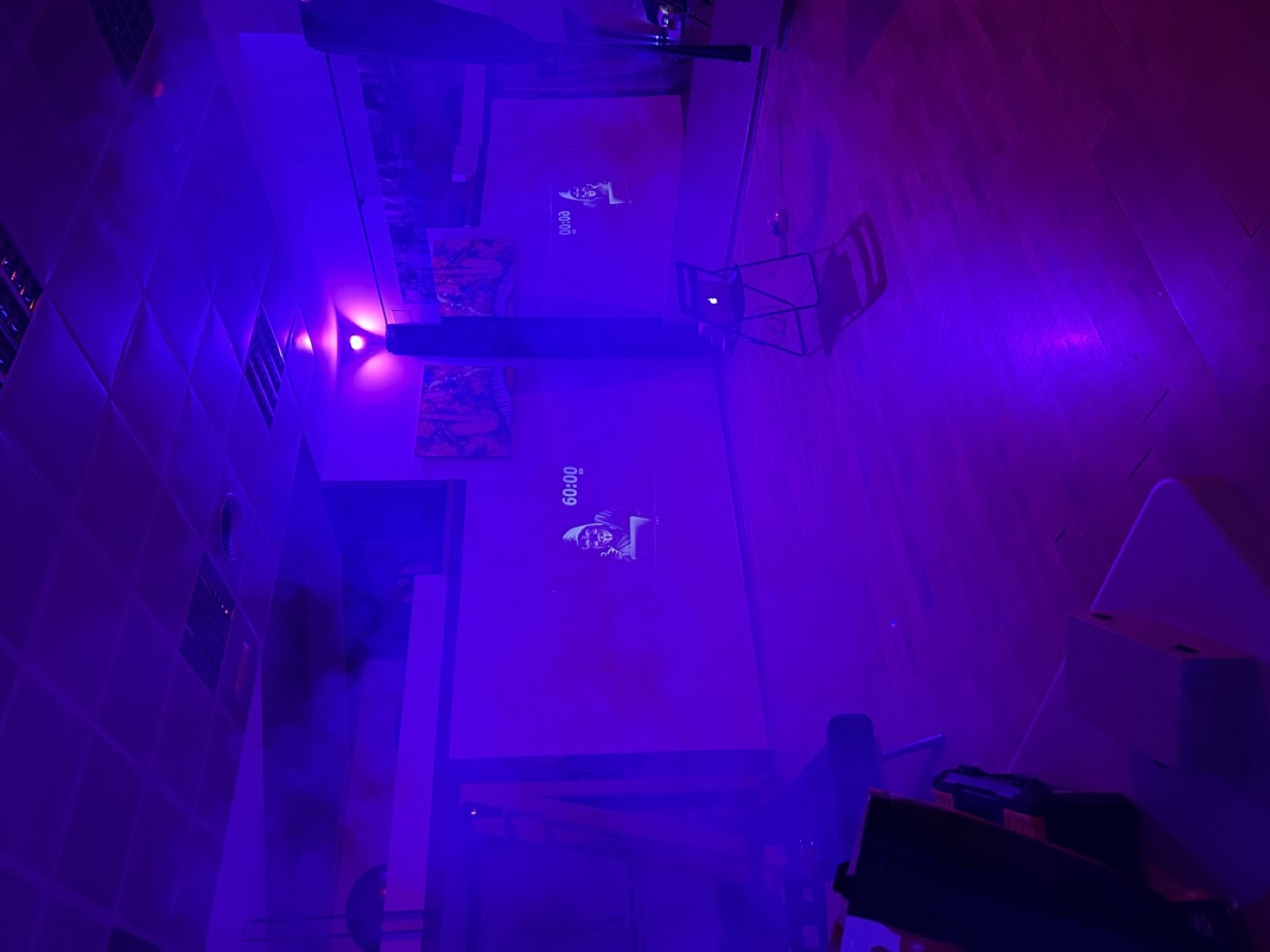 Niños jugando un escape room a domicilio Picapista alrededor de la caja del juego con luces y dispositivos en una sala con iluminación inmersiva en Madrid